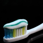 Photo de brosse à dents blanche avec du dentifrice blanc à rayure verte